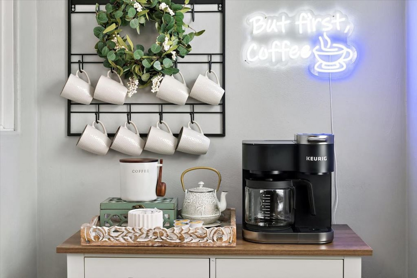 Chic coffee corner with modern appliances and neon sign, crafted by Kindred Design.