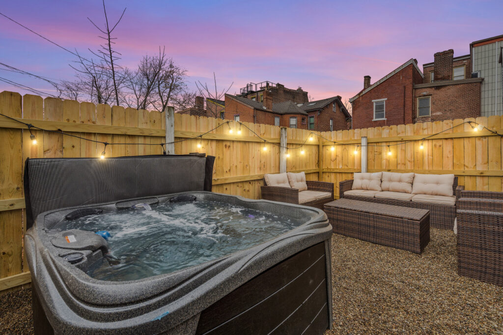 Inviting outdoor jacuzzi area with comfortable seating and ambient lighting designed by Kindred Design.